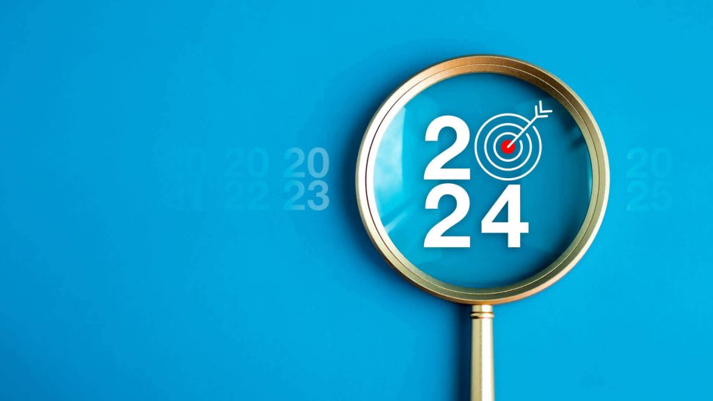 عدسة مكبرة تركز على عام 2024 مع رمز هدف، تمثل اتجاهات التسويق 2024.