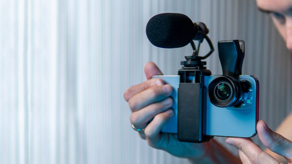 A content manager holds a microphone and camera setup, symbolizing content creation and management. Represents local content creation in Saudi Arabia, content writing, and user-generated content production.